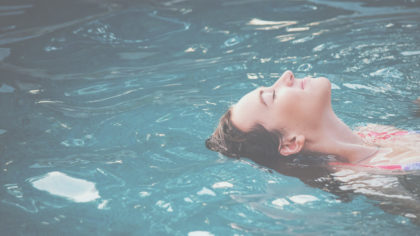 Woman lying back floating in water