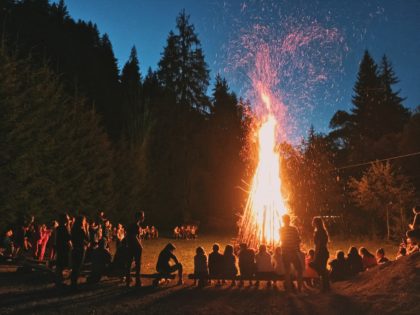 Litha bonfire in the woods with a ring of people